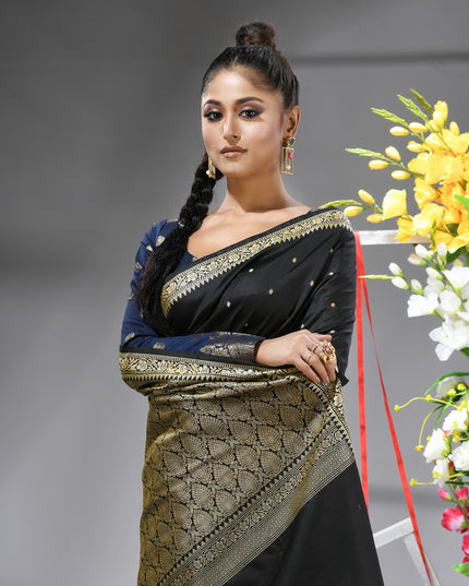Close-up of silver zari butti on black pure silk saree.