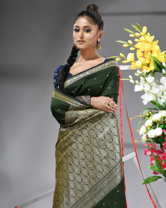 Close-up of silver zari butti on dark green pure silk saree.