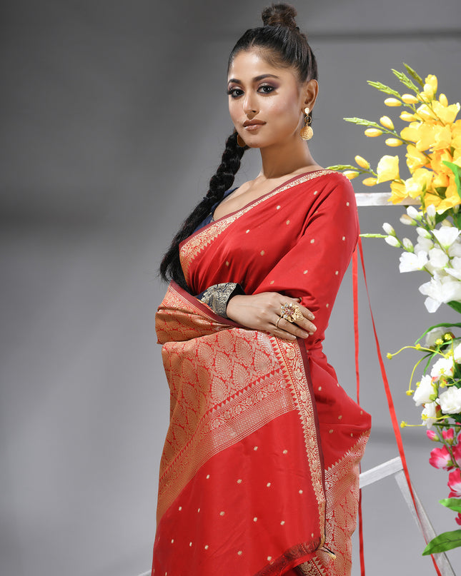 Close-up of silver zari butti on red pure silk saree.