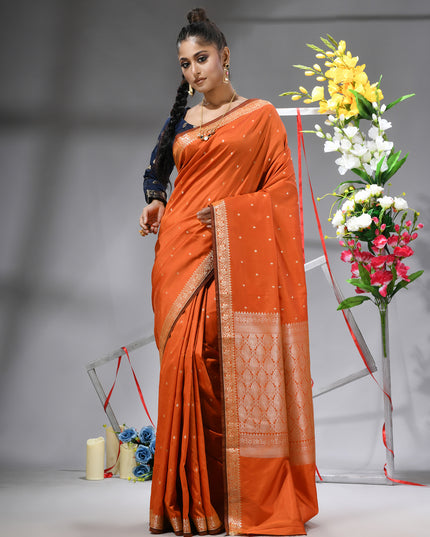 Vibrant orange Kanchipuram silk saree with intricate jacquard weave.