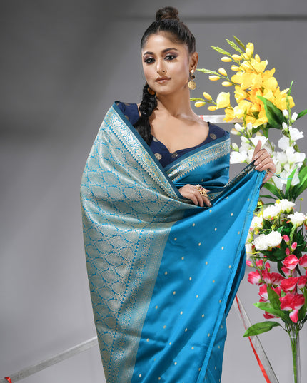 Close-up of silver zari butti on sea blue pure silk saree.
